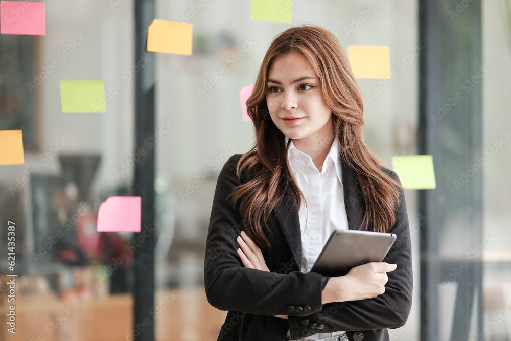 Successful businesswoman standing in creative office and looking at camera. Woman entrepreneur in a co-working space smiling. Portrait of beautiful business woman standing. Successful businesswoman standing in creative office and looking at camera. Woman entrepreneur in a co-working space smiling. Portrait of beautiful business woman standing.