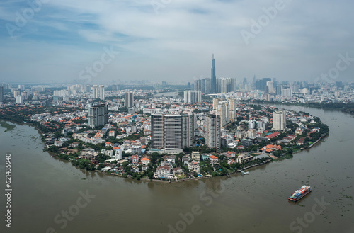 Classic aerial view of Ho Chi Minh City on a sunny day from Thao Dien with container boats working on Saigon River. Landmark building and city skyline can be seen in background. 