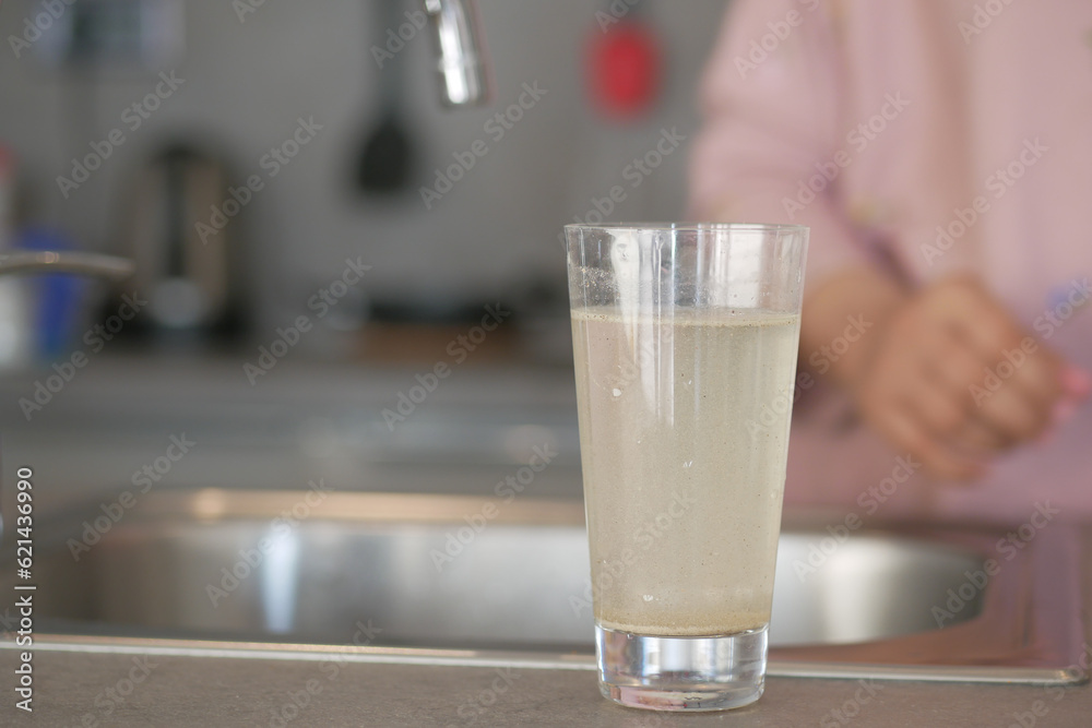 dirty water pouring from a faucet tap in a glass, dirty water pouring from a faucet tap in a glass,