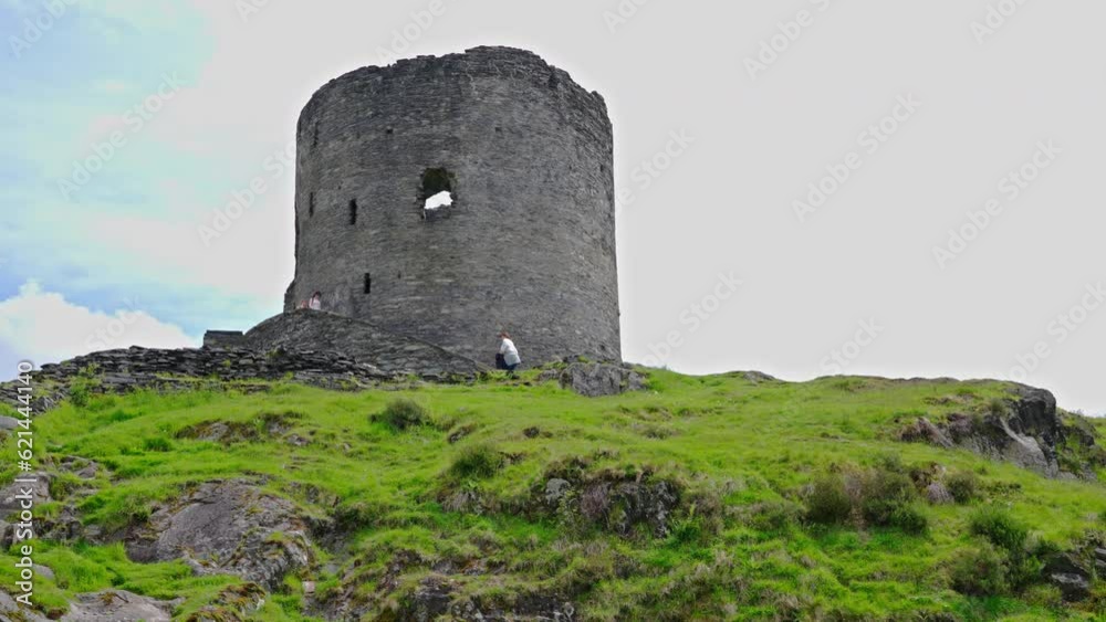 Low angle wide shot of tourists descending the stairs of Dolbadarn Castle on a spring afternoon, in the town of Llanberis, Wales, UK Low angle wide shot of tourists descending the stairs of Dolbadarn Castle on a spring afternoon, in the town of Llanberis, Wales, UK