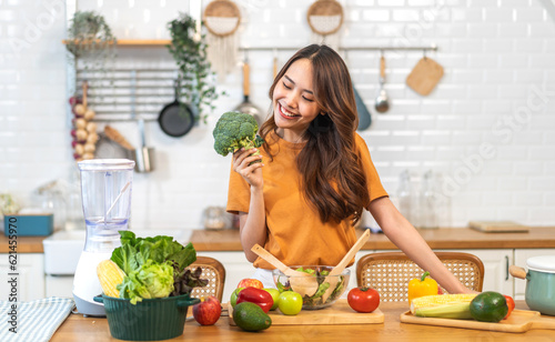 Portrait of beauty body slim healthy asian woman having fun cooking and preparing cooking vegan food healthy eat with fresh vegetable salad on counter in kitchen at home.Diet.Fitness  healthy food