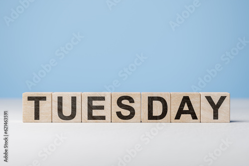 Word Tuesday on wooden cubes. Weekday concept. Tuesday inscription on wooden cubes on blue background. copy space