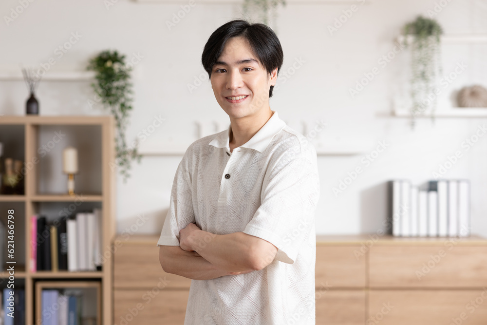 Asian handsome man standing cross arm looking at camera smile at home.Happy young smart businessman smile and confidence.Positive and good moment of asian male worker smile with wellness life Asian handsome man standing cross arm looking at camera smile at home.Happy young smart businessman smile and confidence.Positive and good moment of asian male worker smile with wellness life