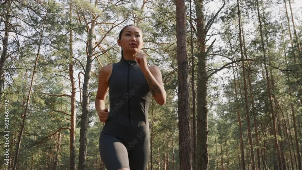 Young female athlete jogging in forest Young female athlete jogging in forest