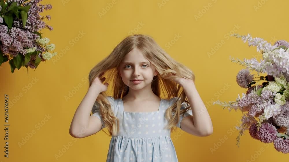 The 7 year old little girl is dressed in a light blue dress and looks