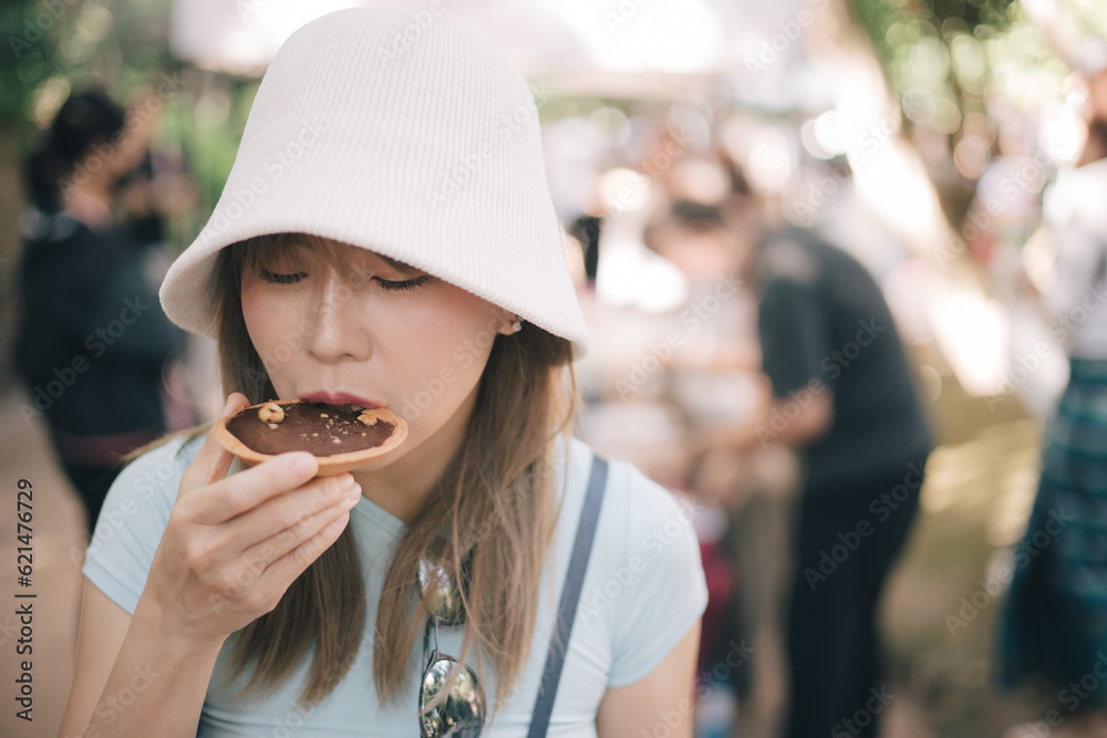 Woman standing and eating chocolate tart Woman standing and eating chocolate tart