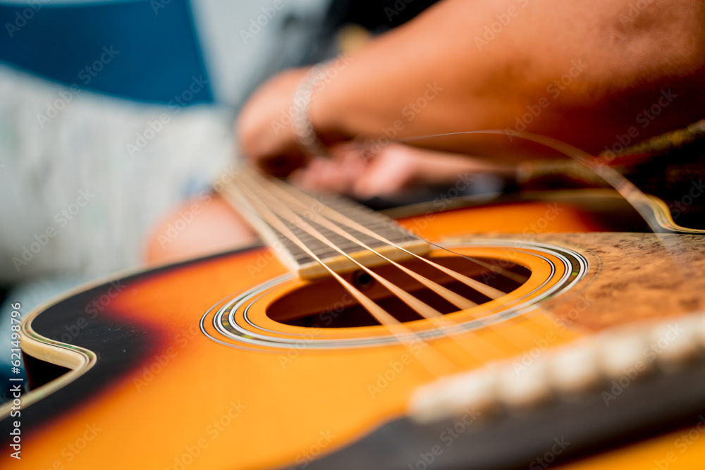 Young musician changing strings on a classical guitar in a guitar shop