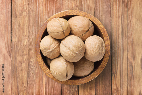 Photos shelled walnut, chilean in bowl on wooden table background, top view