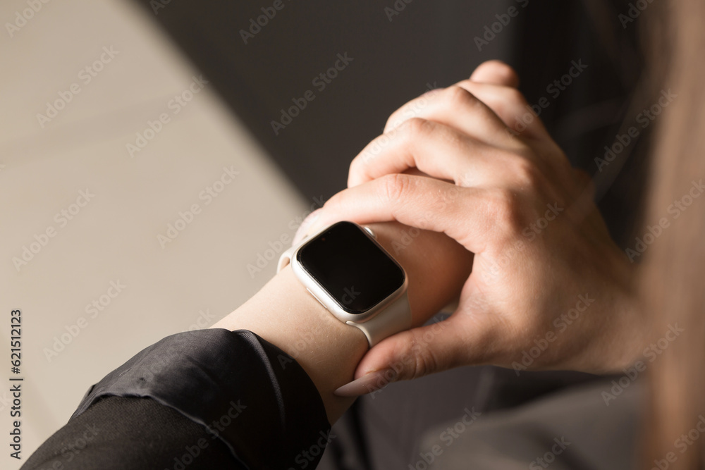 Young office worker looking at smart watch, close-up, copy space