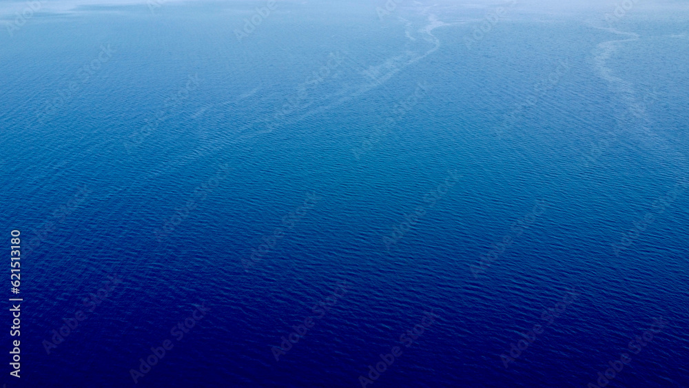 Deep blue sea. Blue sea surface background. Marine texture. Aerial view of the sea surface and small waves. Deep blue sea. Blue sea surface background. Marine texture. Aerial view of the sea surface and small waves.