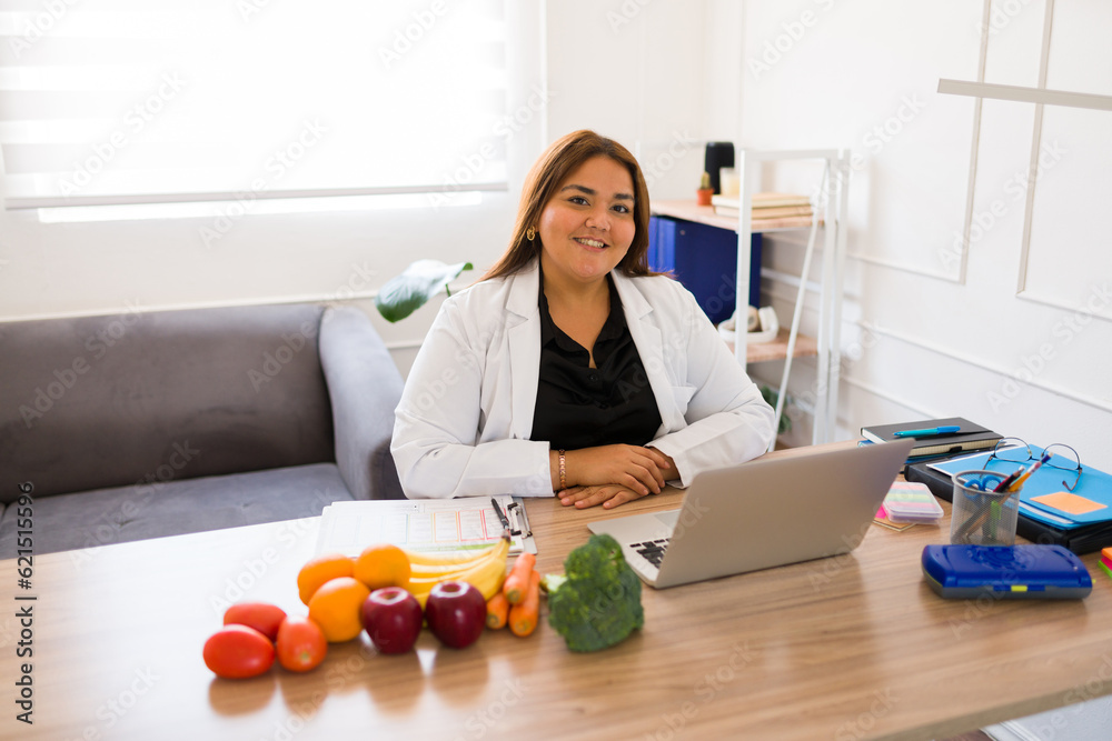 Smiling fat nutritionist feeling happy working in her office