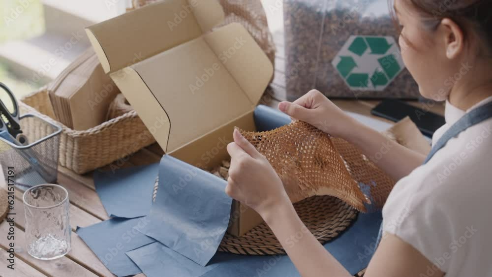 Eco friendly go green packaging parcel carton box in net zero waste store asian seller retail shop. Save the planet earth care ESG small SME owner asia people wrap reuse paper pack gift reduce garbage