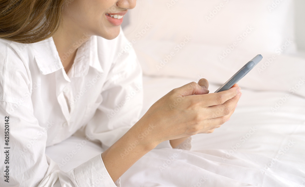 Relaxed woman using smart phone in the morning in bed at home. Relaxed woman using smart phone in the morning in bed at home.
