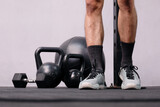 fitness equipment dumbbell kettlebell on black background and young male exerciser