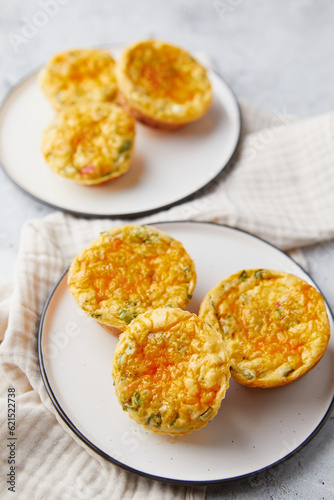 Savory muffins with egg, feta cheese, cheddar and spinach on light background