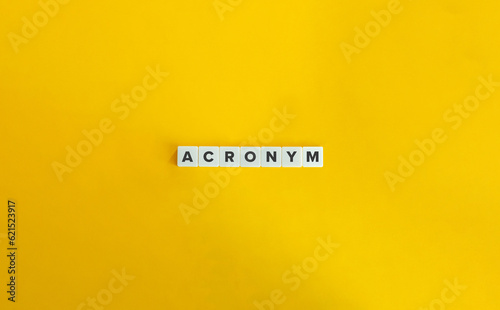 Acronym Word on Block Letter Tiles on Yellow Background. Minimal Aesthetic.