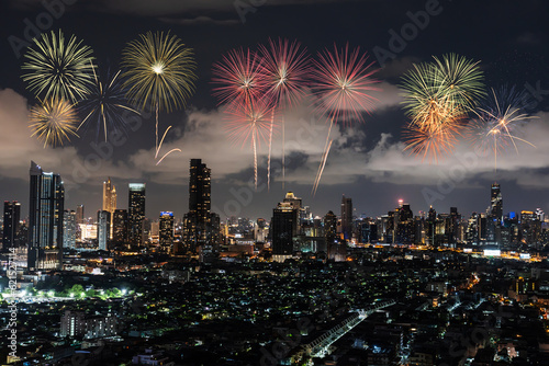New Year colorful firework celebration in Bangkok city skyline with Twilight night, Many hotel, temple and height building for business stand in the heart of Bangkok,Thailand.