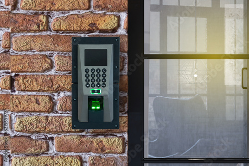 Finger print scan devices machine on brick wall for access door security and time record.