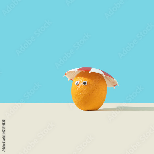 The orange fruit looks at the Sun. Creative, minimal, surreal concept of health, long life, light therapy treatment. Front view. Copy space. © CocoM7-1
