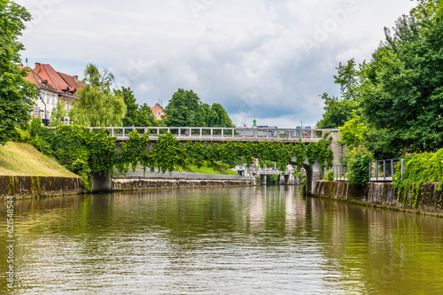 A view on the Ljubljanica River towards the Saint James Bridge looking towards the center of Ljubljana, Slovenia in summertime photo