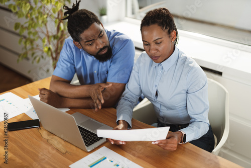 African American business couple working on a computer in the office. Focus is on woman