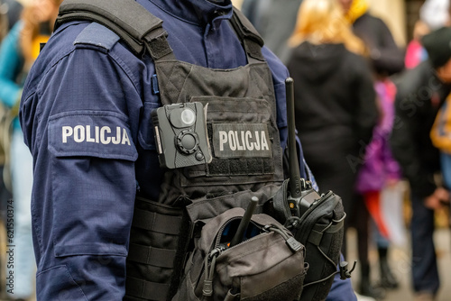 Polish police officer, anonymous unrecognizable policeman in a black bodycam vest, body camera, radio, accessories and equipment detail, closeup, one person. Emergency services simple concept