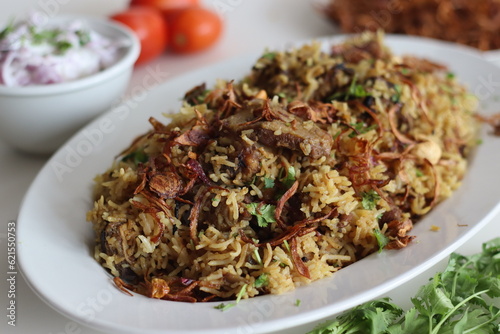 Mutton Biryani prepared with spices layered between mildly spiced ghee rice with a generous sprinkle of caramelized onions and Mutton marinated in yogurt photo