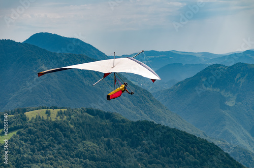 Vintage hang glider flies in the mountains