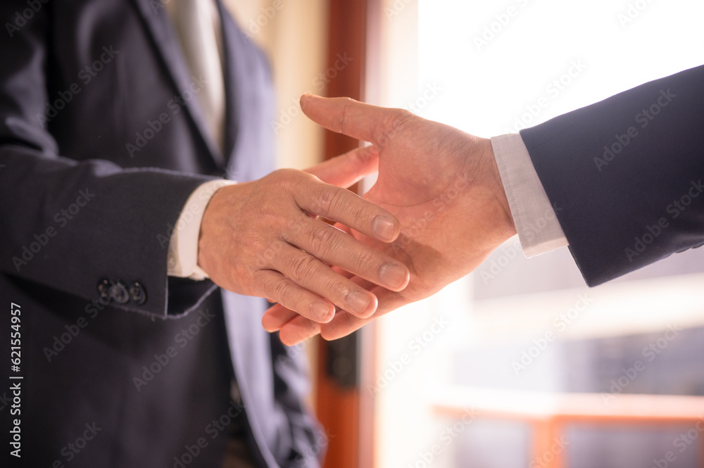 Obraz premium businessman shake hand with partner to celebration partnership and business deal concept, Businessman handshake for teamwork of business merger and acquisition, successful negotiate, hand shake