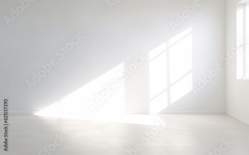 An empty room with a bright white wall and a window.