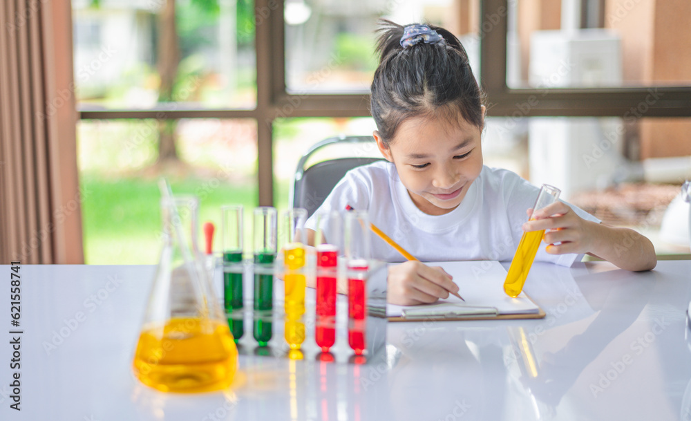little scientist looking through a microscope and test tubes filled with chemicals for learning about science and experiments. little scientist looking through a microscope and test tubes filled with chemicals for learning about science and experiments.