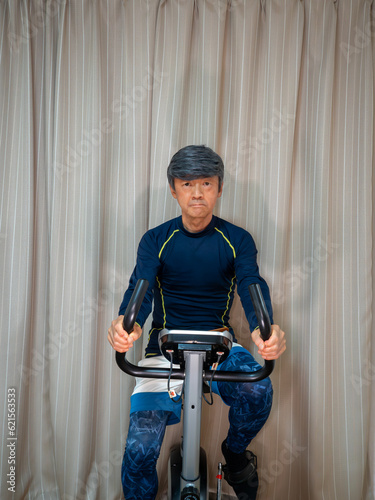 Senior man training on a fitness bike (exercise bike)