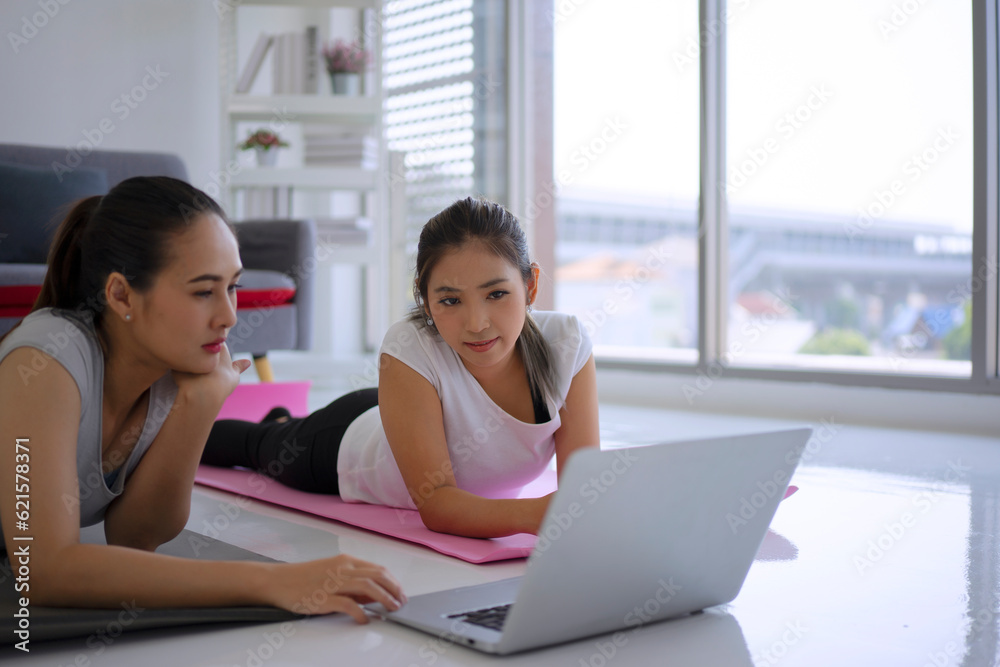Women play yoga at home. Healthy lifestyle and friendship concept Women play yoga at home. Healthy lifestyle and friendship concept
