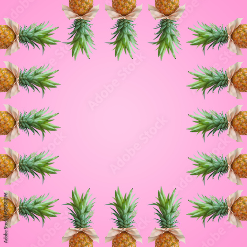 Bonbon candy frame made of pineapple fruit with pink bows on pastel pink background. Original summer design. Minimal fruit concept. Creative advertisement idea. Fruit candy. Copy space  template.
