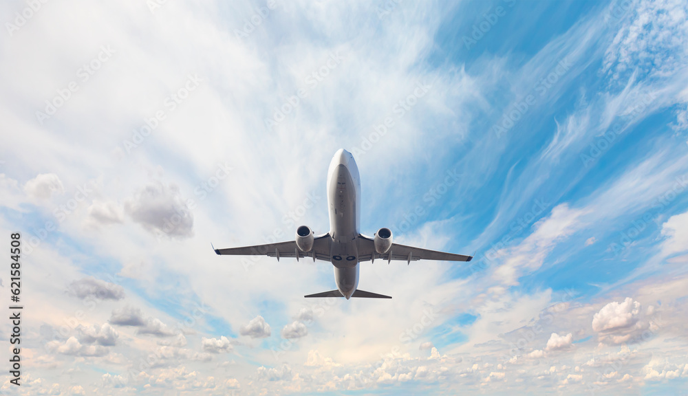 Obraz premium White passenger airplane flying in the sky amazing clouds in the background - Travel by air transport