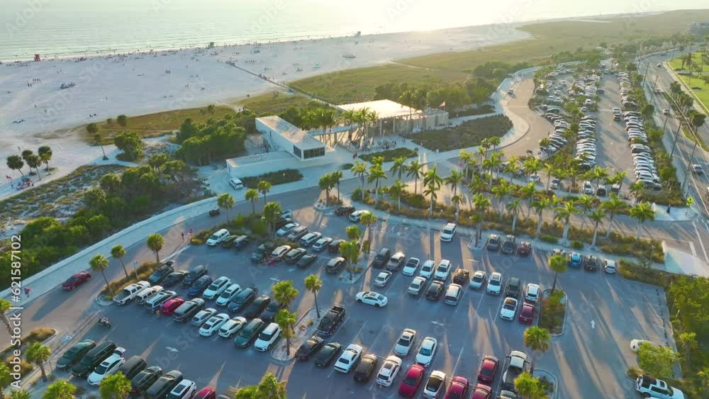 Aerial view of parking lot for tourists cars in front of famous Siesta Key beach in Sarasota, USA. Popular vacation spot in warm Florida at sunset