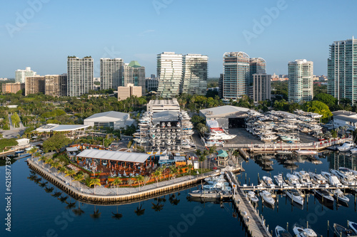 Aerial view of waterfront bars, restaurants and marina in Coconut Grove, Miami, Florida with skyline in background on calm clear sunny summer morning.