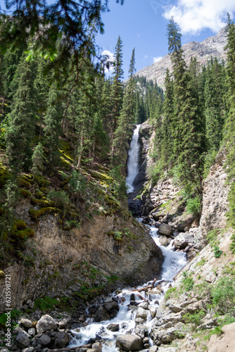 Waterfalls in the Barskoon Gorge among trees and mountains, stones, Manas Bowl, Tears of Bars in Kyrgyzstan
