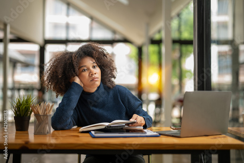 business woman sitting absent-minded Pondering while taking a break from the job in front of her. feeling bored and tired