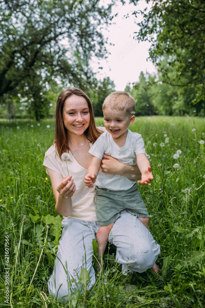 Young woman mom and son play in nature, spend time together and have fun