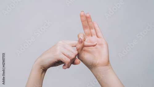 Provocative gesture. Fuck off. Woman hands showing finger in hole isolated on gray free space background. photo