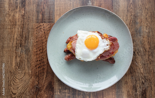 Simply breakfast hashbrown, bacon, egg and sausage on a wooden table. photo