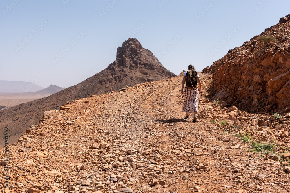 Hiking up the mount Zagora on a gravel road, mount Adafane in the background, Draa valley
