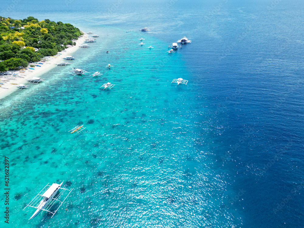 Obraz premium Beautiful beaches and hopping boats on Balikasak Island, Bohol, Philippines, a sacred place for scuba diving (traditional Philippine boats, banca)