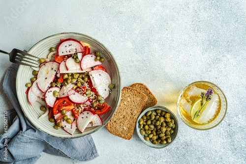 Vegetable salad with organic tomato and capers, lemonade and bread photo