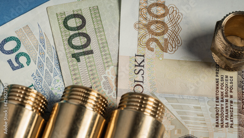 warsaw, poland - 07 07 2023: Polish banknotes of PLN and hydraulic brass connectors lying on them (selective focus)