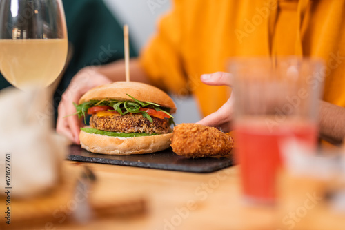 Crop person with hamburger in restaurant photo