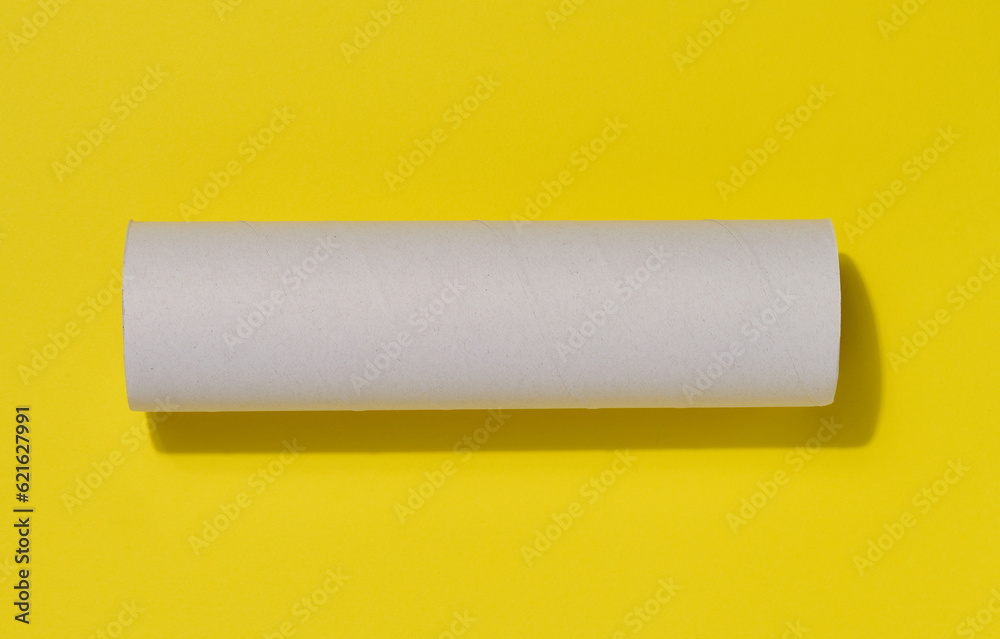 White paper towel from a roll of kitchen towels, object on a yellow background, top view White paper towel from a roll of kitchen towels, object on a yellow background, top view