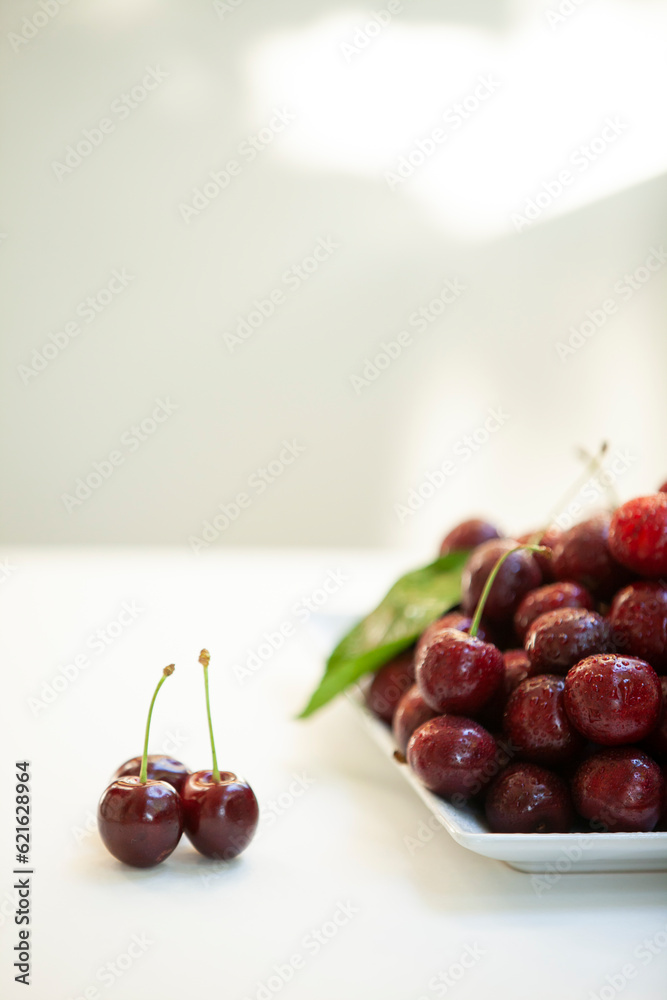 Juicy sweet cherry with water drops on a plate.