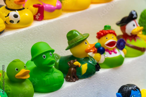 Toy rubber ducks with different characterizations, on a store shelf.